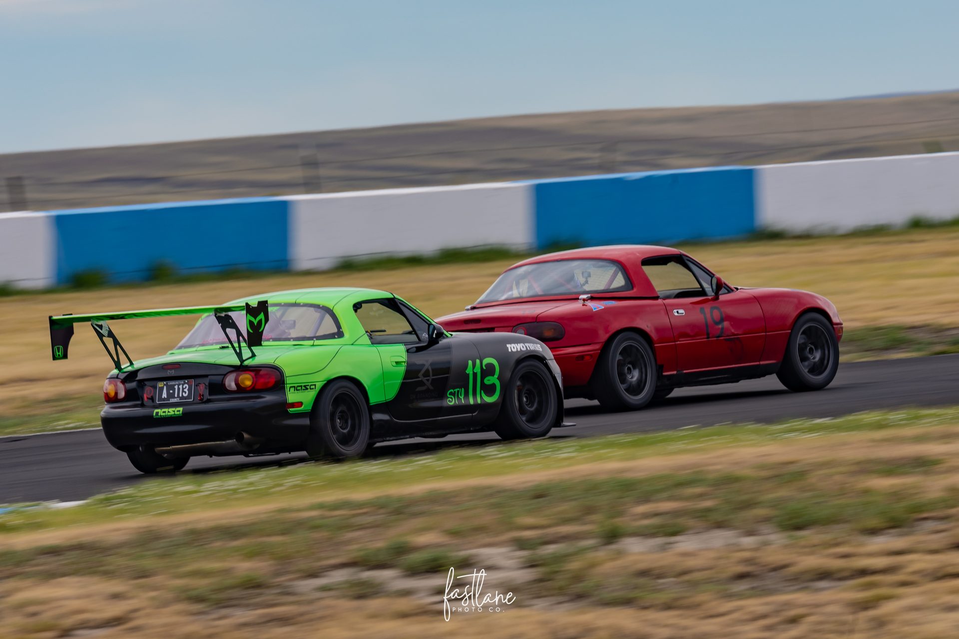 LeadFoot Racing Spec Miata #19 in traffic exiting a corner at High Plains Raceway