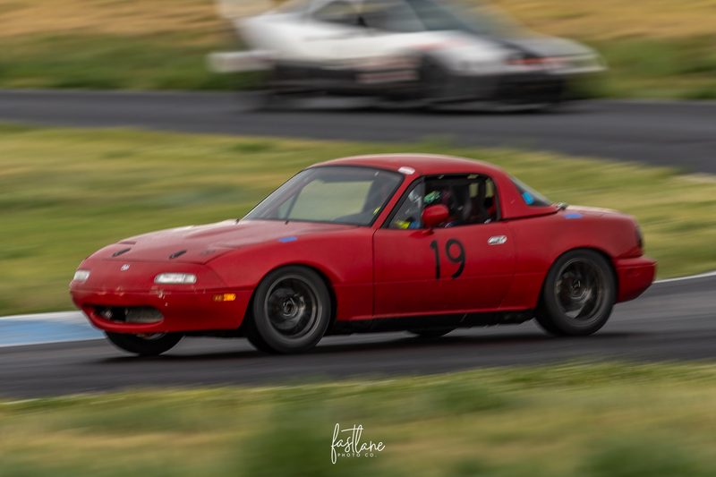 The #19 Spec Miata running its own line through traffic at High Plains Raceway